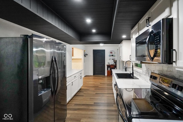 955 Wood Creek Pl, Greenwood, IN 46142 - kitchen featuring stainless steel appliances, a sink, wood finished floors, white cabinets, and tasteful backsplash