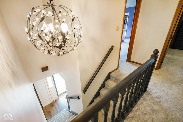 955 Wood Creek Pl, Greenwood, IN 46142 - staircase featuring a chandelier, carpet, a towering ceiling, and baseboards