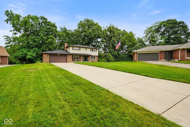 955 Wood Creek Pl, Greenwood, IN 46142 - traditional-style home with a garage, a front lawn, driveway, brick siding, and a chimney