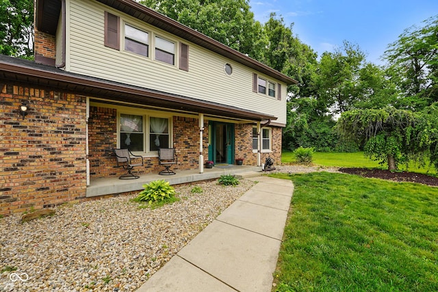 955 Wood Creek Pl, Greenwood, IN 46142 - view of front of home featuring covered porch, a front yard, and brick siding