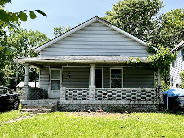 2826 Station St, Indianapolis, IN 46218 - view of front of property with a porch, a front lawn, and stone siding