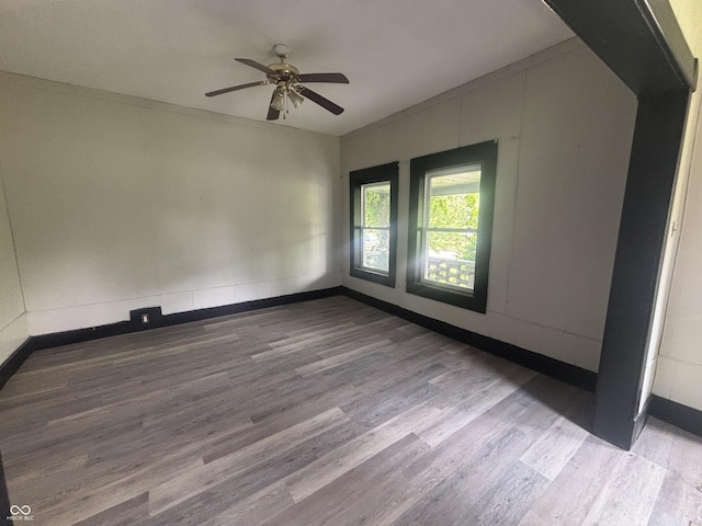 2826 Station St, Indianapolis, IN 46218 - spare room featuring wood finished floors, a ceiling fan, baseboards, vaulted ceiling, and ornamental molding