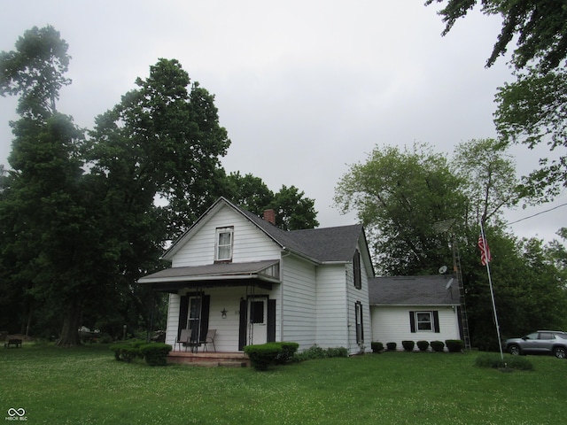112 Orchard St, Waynetown, IN 47990 - view of front of house with covered porch, a front lawn, roof with shingles, and a chimney