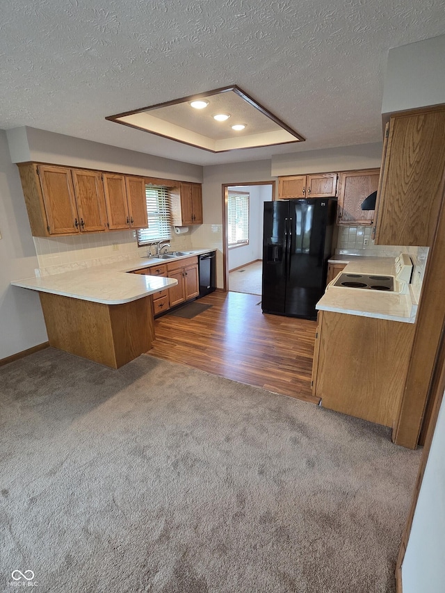 1201 Briarwood Dr, Brownsburg, IN 46112 - kitchen with black appliances, a peninsula, brown cabinetry, dark colored carpet, and a textured ceiling