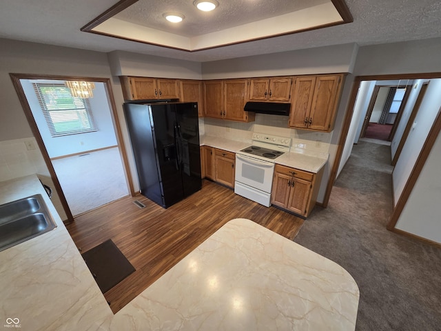 1201 Briarwood Dr, Brownsburg, IN 46112 - kitchen featuring white range with electric stovetop, black fridge, under cabinet range hood, a textured ceiling, and brown cabinets