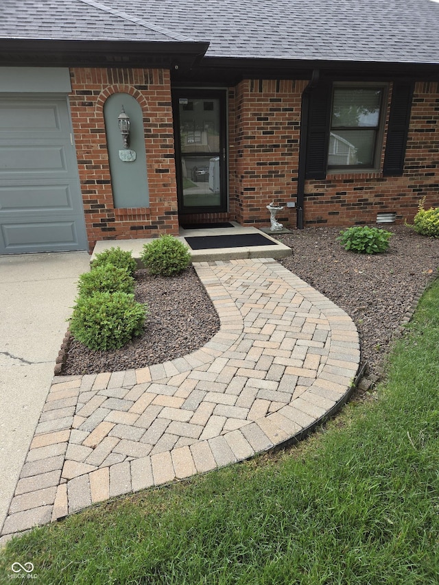 1201 Briarwood Dr, Brownsburg, IN 46112 - property entrance featuring brick siding, a shingled roof, concrete driveway, and an attached garage