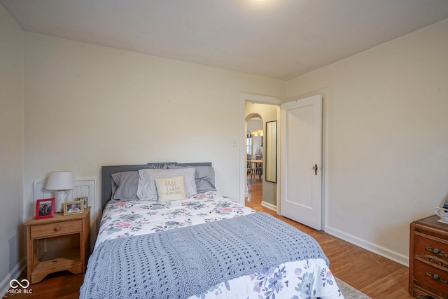 5435 E 10th St, Indianapolis, IN 46219 - bedroom with wood finished floors, arched walkways, and baseboards