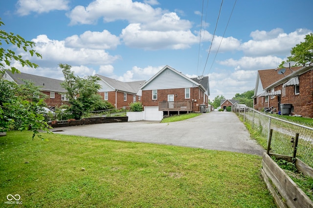 5435 E 10th St, Indianapolis, IN 46219 - rear view of property with asphalt driveway, brick siding, and a garage