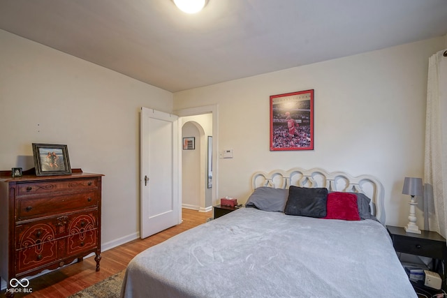 5435 E 10th St, Indianapolis, IN 46219 - bedroom with wood finished floors, arched walkways, and baseboards