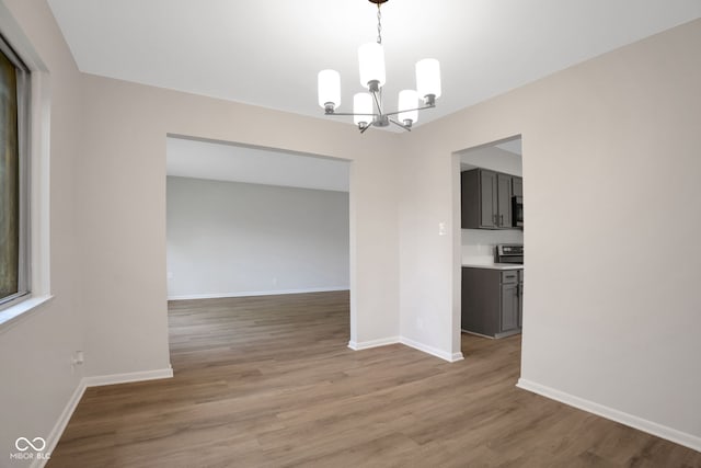 3148 Arbutus Dr, Indianapolis, IN 46224 - spare room with a chandelier, baseboards, and light wood-type flooring