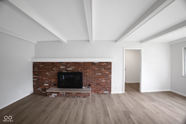 3148 Arbutus Dr, Indianapolis, IN 46224 - unfurnished living room featuring wood finished floors, a fireplace, beamed ceiling, and baseboards