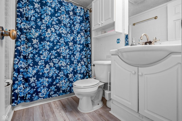 5811 Simmul Cir, Indianapolis, IN 46221 - bathroom featuring a textured ceiling, wood finished floors, toilet, vanity, and curtained shower