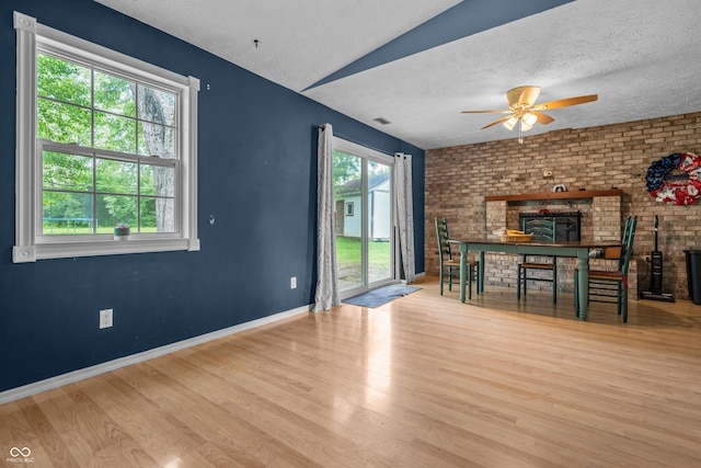 5811 Simmul Cir, Indianapolis, IN 46221 - unfurnished living room featuring wood finished floors, a ceiling fan, a textured ceiling, baseboards, and a brick fireplace