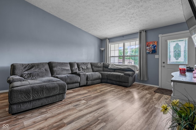 5811 Simmul Cir, Indianapolis, IN 46221 - living room featuring a textured ceiling, wood finished floors, vaulted ceiling, and baseboards