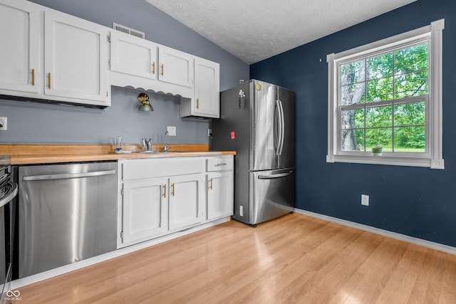 5811 Simmul Cir, Indianapolis, IN 46221 - kitchen with stainless steel appliances, a textured ceiling, light wood-type flooring, white cabinetry, and a sink