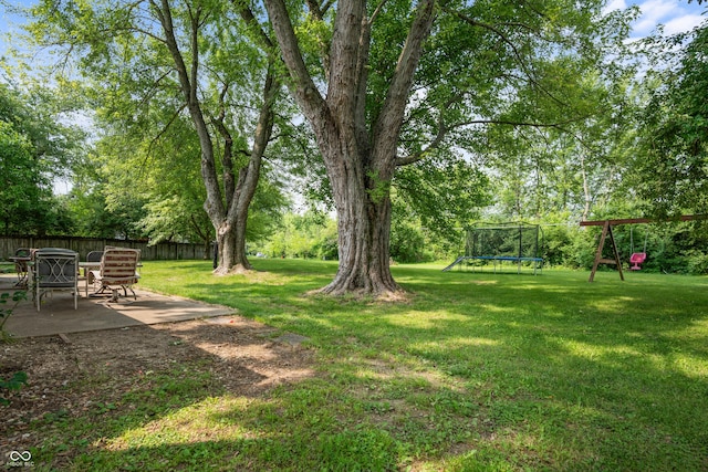 5811 Simmul Cir, Indianapolis, IN 46221 - view of yard featuring a patio area, a trampoline, and a playground