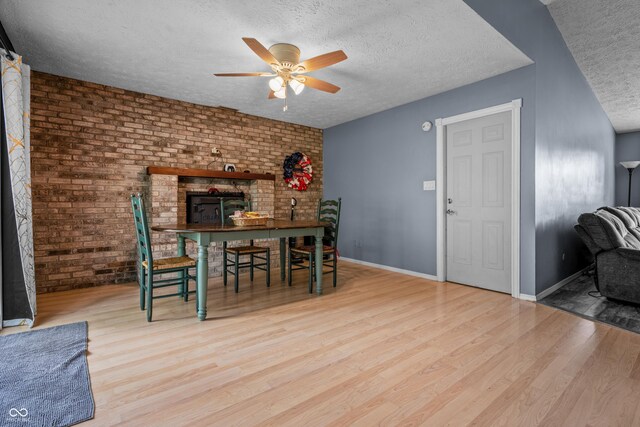5811 Simmul Cir, Indianapolis, IN 46221 - dining room with a textured ceiling, ceiling fan, wood finished floors, brick wall, and baseboards