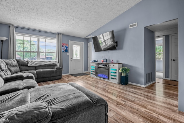 5811 Simmul Cir, Indianapolis, IN 46221 - living area with a textured ceiling, wood finished floors, vaulted ceiling, and baseboards