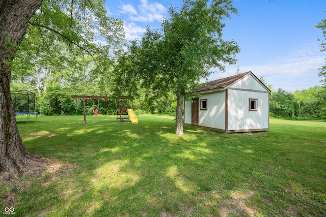 5811 Simmul Cir, Indianapolis, IN 46221 - view of grassy yard with a trampoline, a playground, and an outbuilding