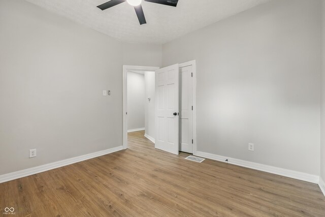 2831 N Talbott St, Indianapolis, IN 46205 - unfurnished bedroom featuring baseboards, light wood-style flooring, and ceiling fan