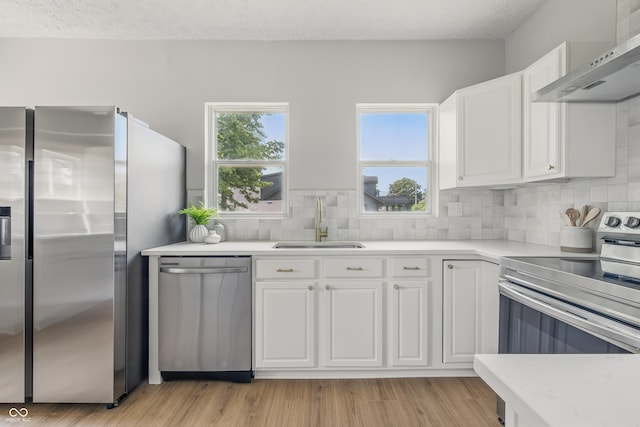 2831 N Talbott St, Indianapolis, IN 46205 - kitchen featuring stainless steel appliances, wall chimney exhaust hood, a sink, plenty of natural light, and a textured ceiling