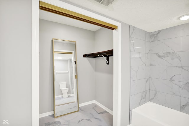 8545 La Corrida Ct, Indianapolis, IN 46227 - bathroom with marble look tiles, toilet,  shower combination, and baseboards