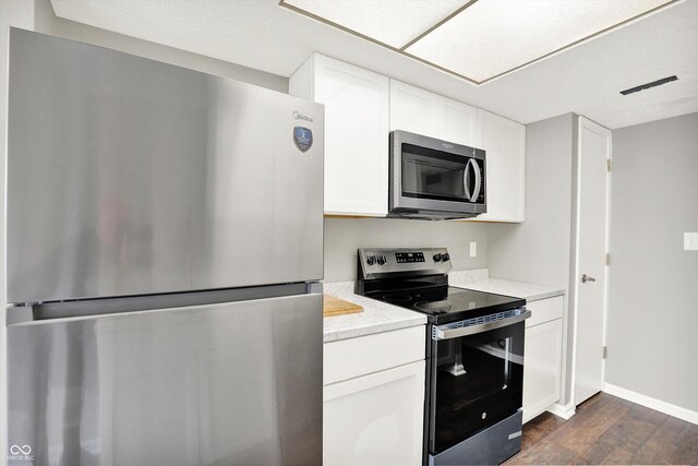 8545 La Corrida Ct, Indianapolis, IN 46227 - kitchen featuring appliances with stainless steel finishes, dark wood-style flooring, white cabinets, and baseboards