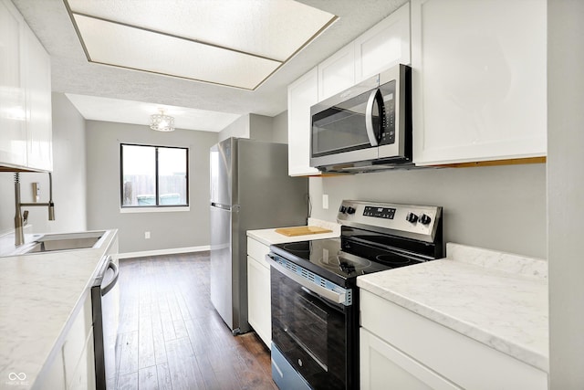 8545 La Corrida Ct, Indianapolis, IN 46227 - kitchen featuring appliances with stainless steel finishes, dark wood finished floors, white cabinets, and a sink