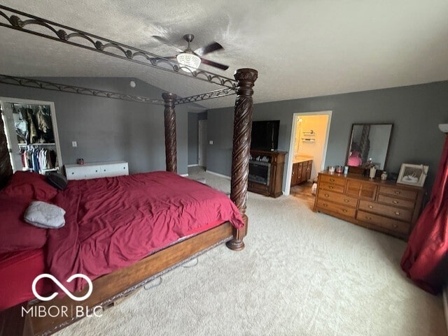 1711 Jaques Dr, Lebanon, IN 46052 - bedroom with carpet flooring, connected bathroom, a ceiling fan, a textured ceiling, and a walk in closet