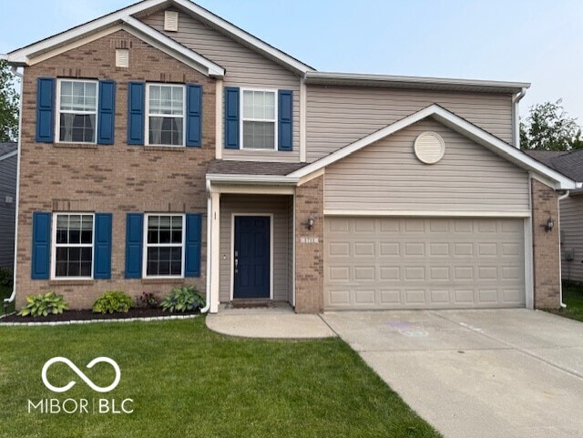 1711 Jaques Dr, Lebanon, IN 46052 - view of front of house featuring brick siding, concrete driveway, and a front lawn