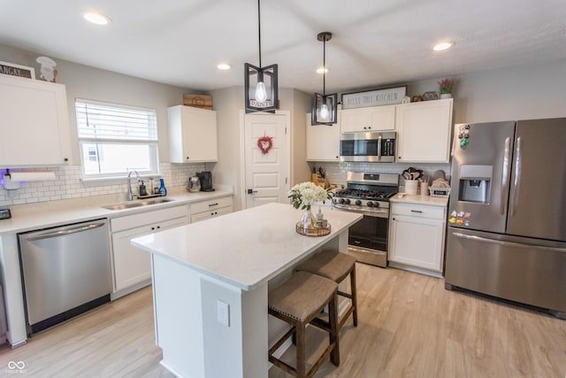 1981 Turning Leaf Dr, Franklin, IN 46131 - kitchen featuring appliances with stainless steel finishes, a sink, backsplash, a kitchen bar, and white cabinets