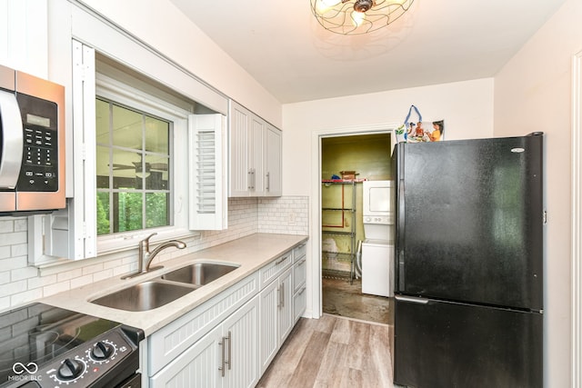 713 W Cromer Ave, Muncie, IN 47303 - kitchen featuring freestanding refrigerator, stacked washer / dryer, stainless steel microwave, range, and light wood finished floors