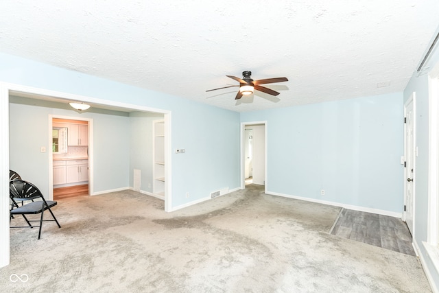 713 W Cromer Ave, Muncie, IN 47303 - unfurnished living room featuring carpet, ceiling fan, and a textured ceiling