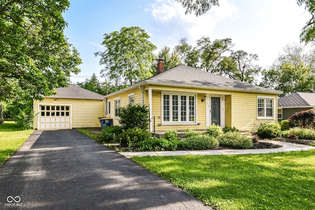 713 W Cromer Ave, Muncie, IN 47303 - view of front of house with a chimney, an outbuilding, a front lawn, driveway, and a detached garage