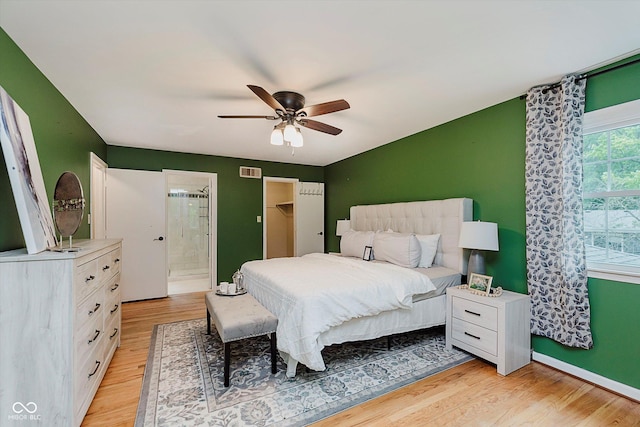 6146 Rucker Rd, Indianapolis, IN 46220 - bedroom with light wood-type flooring, ensuite bathroom, ceiling fan, and a walk in closet