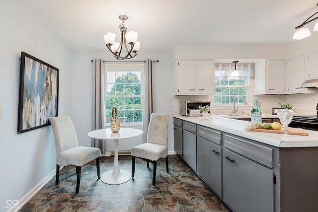 6146 Rucker Rd, Indianapolis, IN 46220 - kitchen featuring gray cabinetry, dark stone finish flooring, a chandelier, and white cabinetry