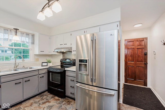 6146 Rucker Rd, Indianapolis, IN 46220 - kitchen with stainless steel fridge, black / electric stove, under cabinet range hood, gray cabinetry, and light countertops