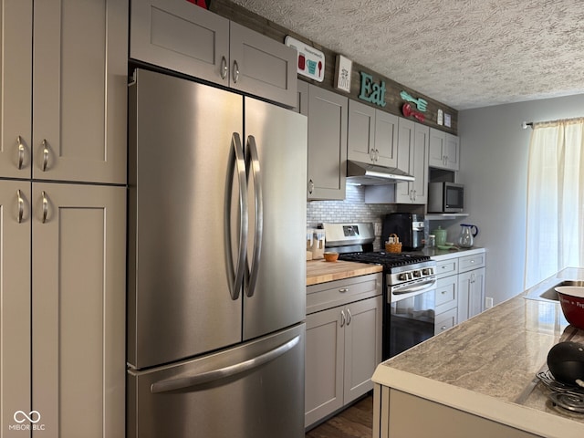 75 Byram Blvd, Martinsville, IN 46151 - kitchen featuring stainless steel appliances, under cabinet range hood, light countertops, decorative backsplash, and a textured ceiling