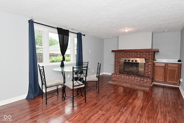 4751 N Longworth Ave, Indianapolis, IN 46226 - dining room featuring dark wood-type flooring, a textured ceiling, baseboards, and a fireplace