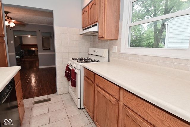 4751 N Longworth Ave, Indianapolis, IN 46226 - kitchen with white gas range, under cabinet range hood, black dishwasher, light countertops, and a ceiling fan