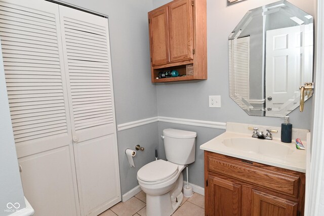 4751 N Longworth Ave, Indianapolis, IN 46226 - bathroom featuring a closet, vanity, toilet, tile patterned flooring, and baseboards