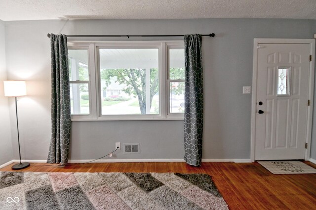 4751 N Longworth Ave, Indianapolis, IN 46226 - entrance foyer featuring healthy amount of natural light, wood finished floors, baseboards, and a textured ceiling