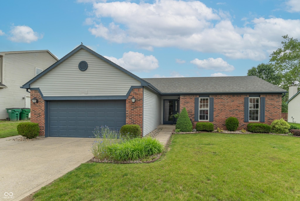 488 Village Blvd, Mooresville, IN 46158 - view of front facade featuring brick siding, an attached garage, driveway, and a front lawn