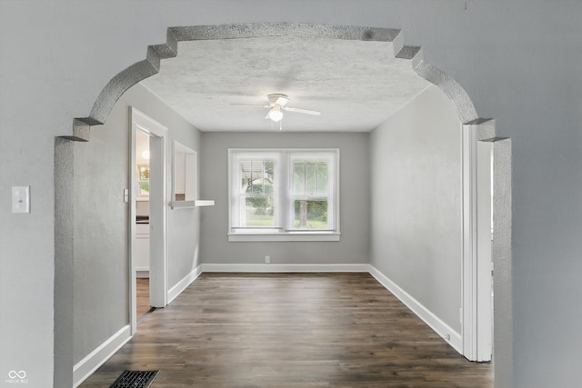 1915 Albany St, Beech Grove, IN 46107 - empty room featuring ceiling fan, dark wood finished floors, baseboards, arched walkways, and a textured ceiling