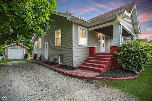 1915 Albany St, Beech Grove, IN 46107 - view of front facade featuring an outdoor structure, driveway, a porch, a detached garage, and entry steps