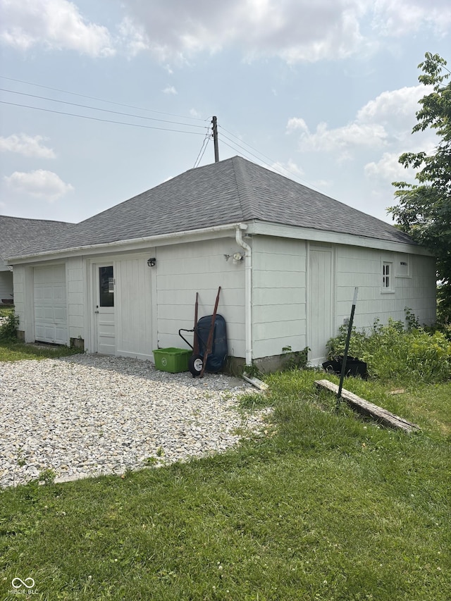 5553 N County Road 10 E, Greensburg, IN 47240 - rear view of property featuring a shingled roof, a lawn, and a garage