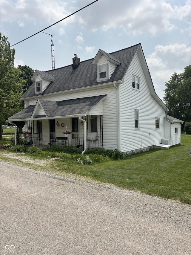 5553 N County Road 10 E, Greensburg, IN 47240 - view of front facade featuring a chimney, covered porch, a front lawn, and a shingled roof