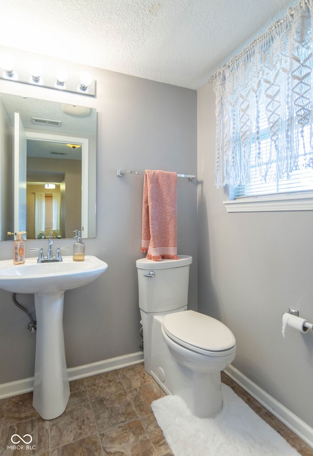 8056 Maple Stream Blvd, Indianapolis, IN 46217 - half bath with toilet, a textured ceiling, baseboards, and a sink