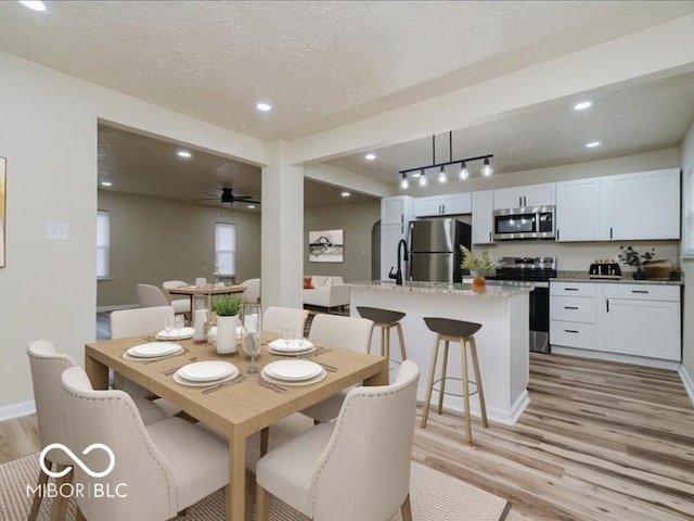 3558 N Gladstone Ave, Indianapolis, IN 46218 - dining room with light wood-style flooring, a ceiling fan, a textured ceiling, baseboards, and recessed lighting
