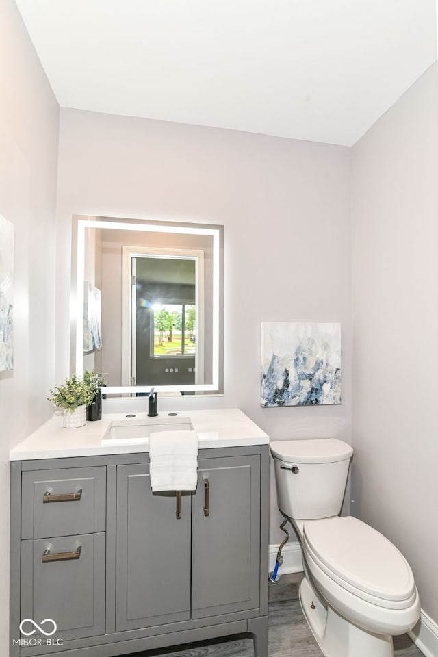 1820 Hemlock Ln, Plainfield, IN 46168 - bathroom featuring toilet, vanity, baseboards, and wood finished floors